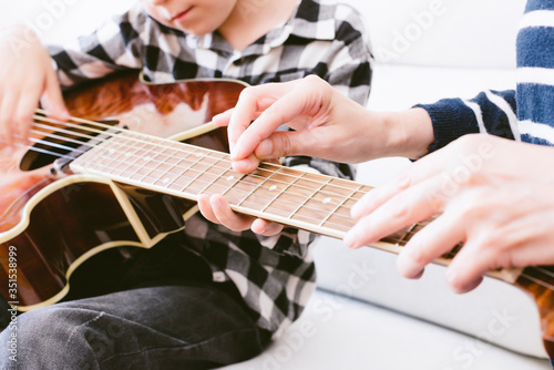 teacher teaching a young guitar boy. selective focus