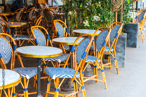 Street view of a coffee terrace with tables and chairs, Paris, France © ilolab