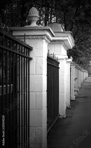 Metal fence  brick columns. Protections of buildings  parks. Black and white photography