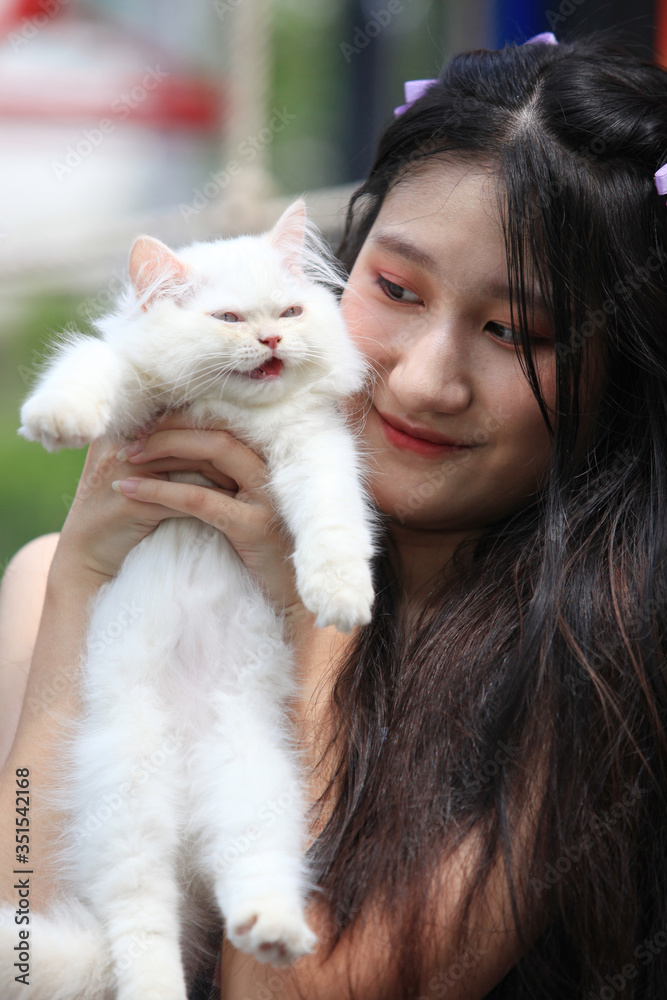 Beautiful young woman with cute white Persian cat resting at home Beautiful young woman with cute white Persian cat resting at home