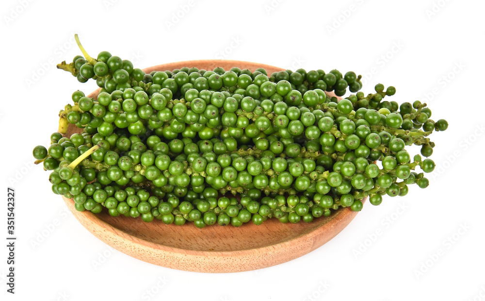 Fresh green peppercorns in wooden dish isolated on a white background.