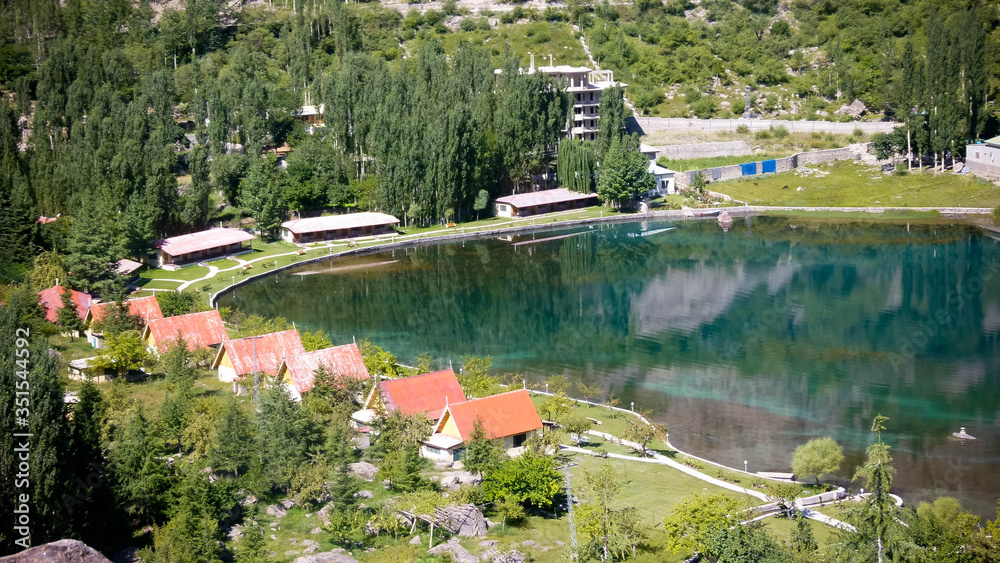Top view of houses and trees with big lake
