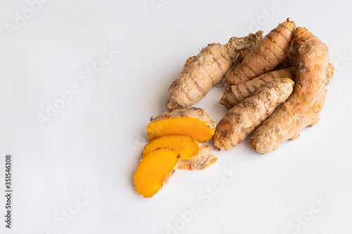 Turmeric root on white background. Tirmeric used as spice and treatment in alternative medicine with multiple benefits for health... photo