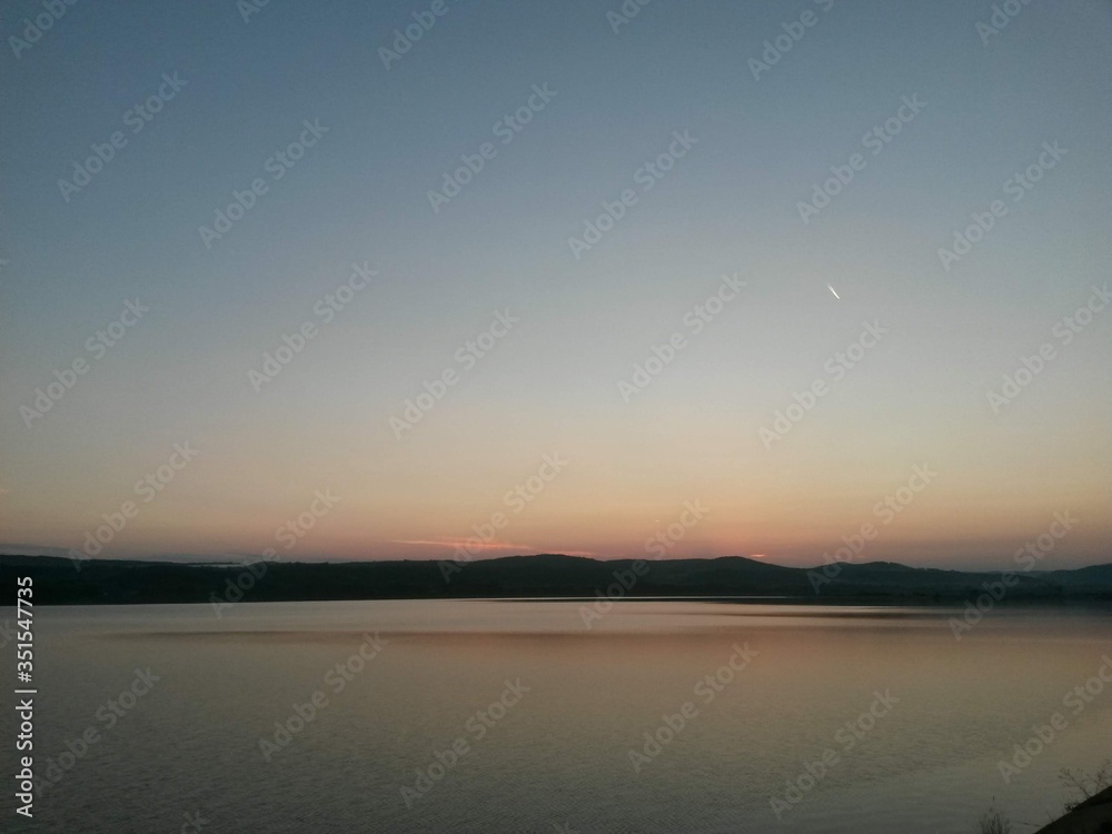lake reflecting sunset with colored clouds in the forest lake reflecting sunset with colored clouds in the forest