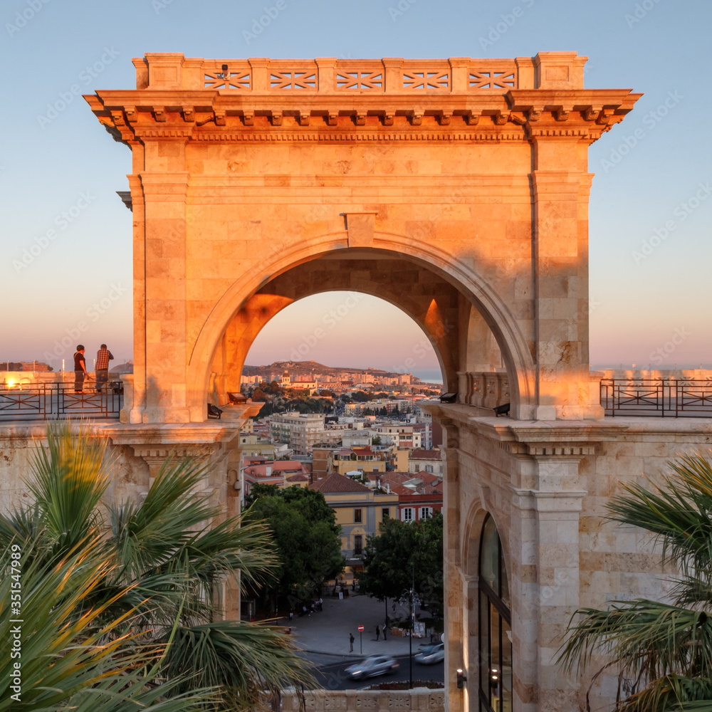 Cagliari, Sardinia, Italy. View of arch of Triumph and the city through the arch from the panoramic terrace on top of the bastion of Saint Remy. Holidays in Sardinia.
