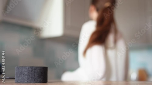The voice assistant in the kitchen plays music, cheerful girl dances in the background