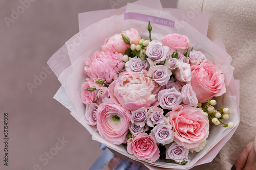 Spring pastel bouquet with roses closeup. Pink peony, ranunculus, roses. Flower shop. Flower wallpaper. Background.