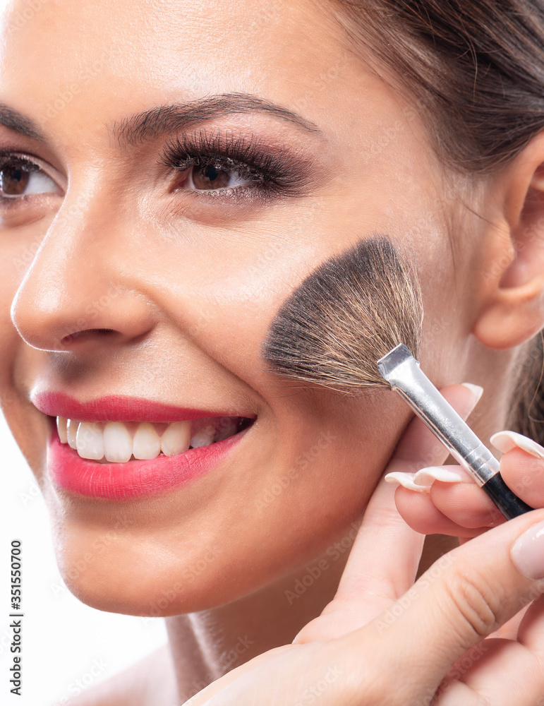 Smiling woman enjoying applying makeup