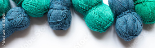 top view of blue and green wool yarn on white background, panoramic orientation