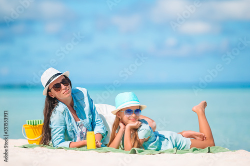 Beautiful mother and daughter at Caribbean beach enjoying summer vacation. © travnikovstudio