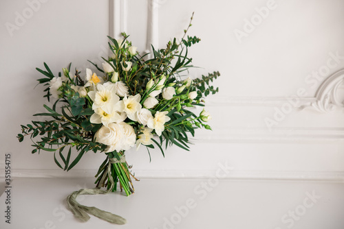 Fototapeta Naklejka Na Ścianę i Meble -  Modern large spring wedding bouquet with daffodils, ranunculus and various greens