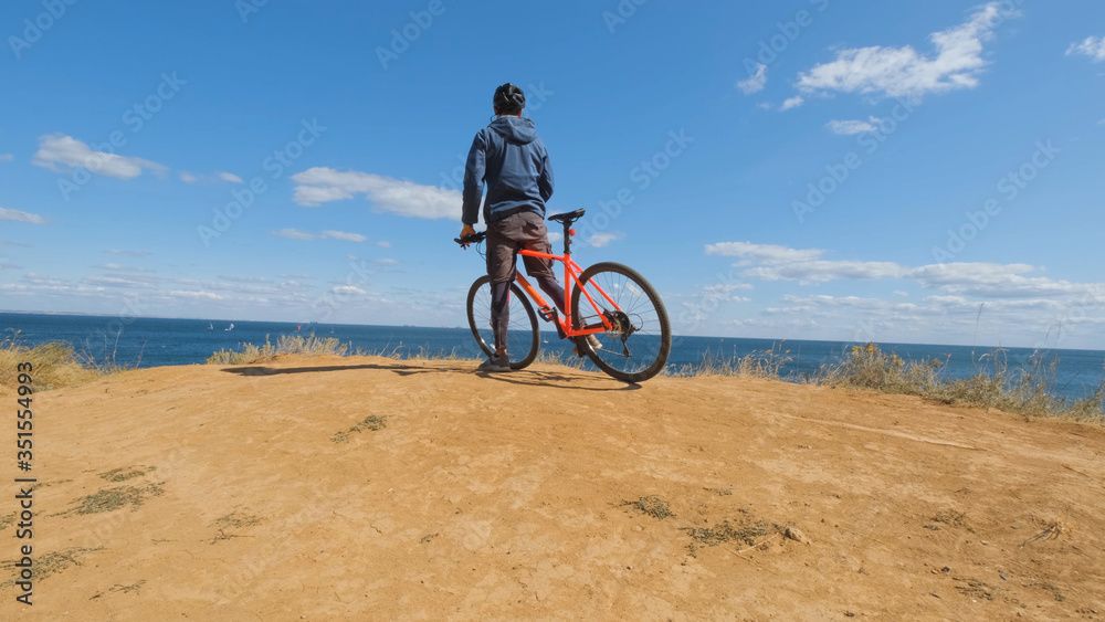 Fototapeta premium Young male on the bicycle with helmet ride on the beach