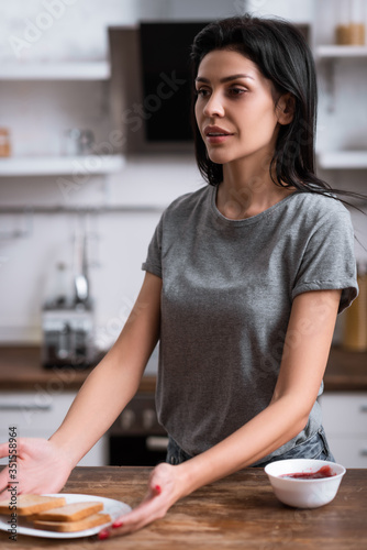 selective focus of woman with bruise on face holding plate with toast bread  domestic violence concept