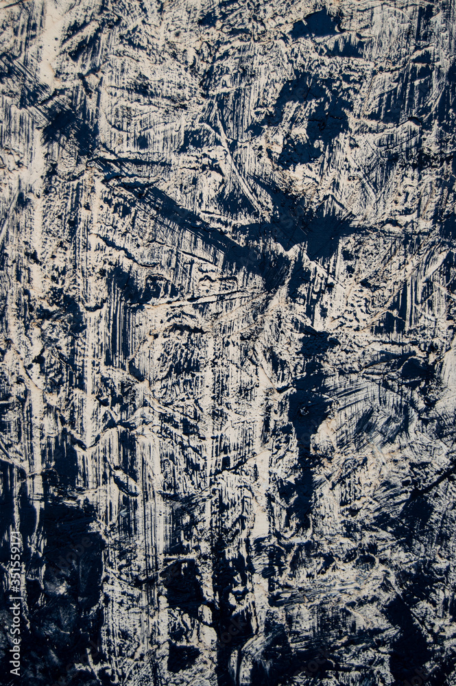 Fototapeta premium Texture background. The beige base is covered with smears of black paint. The view from the top. Texture and background