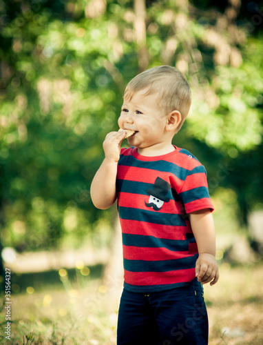 little boy eating cookies in nature