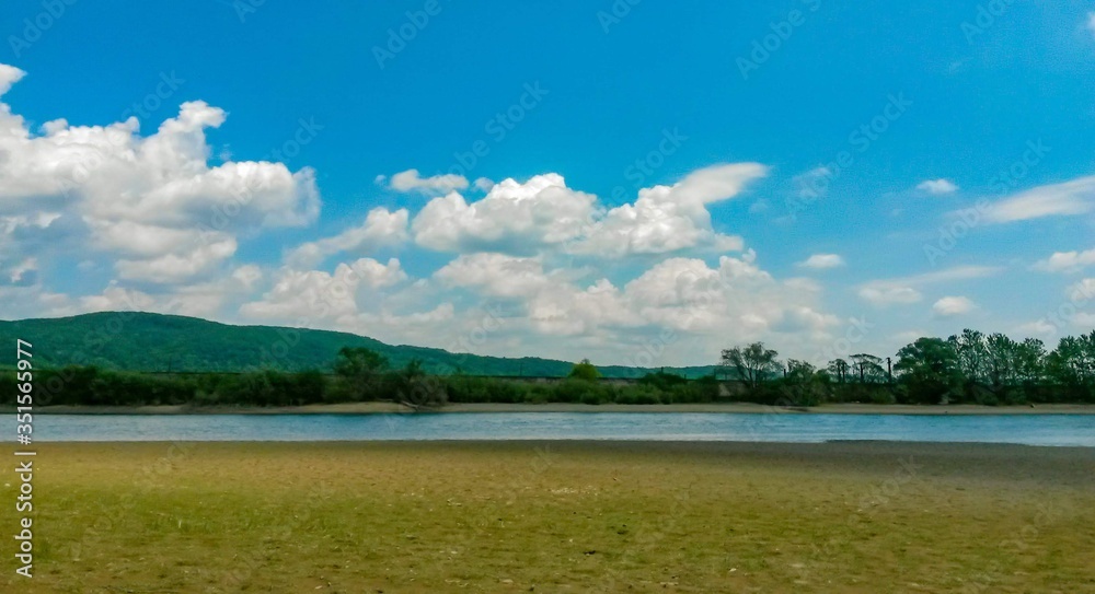 lake in the woods in summer time on sunny day with blue sky