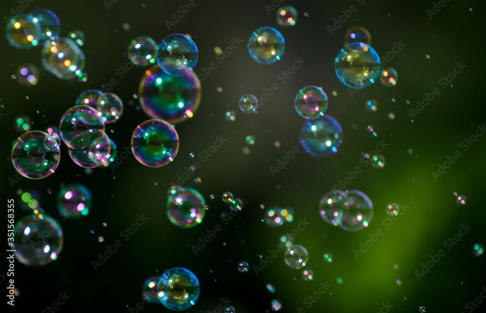 soap bubbles fly on a blurry green background. Concept - the Phantom of Hopes