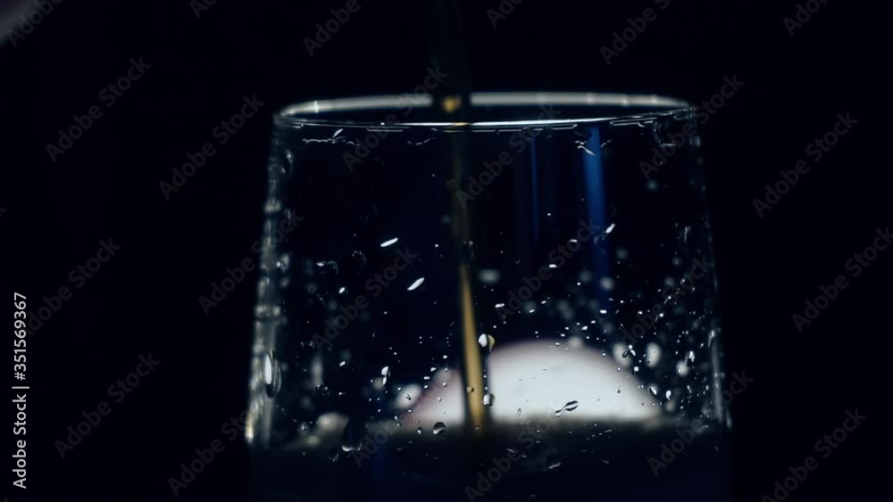 jet of a refreshing drink flows beautifully into a glass beaker jet of a refreshing drink flows beautifully into a glass beaker