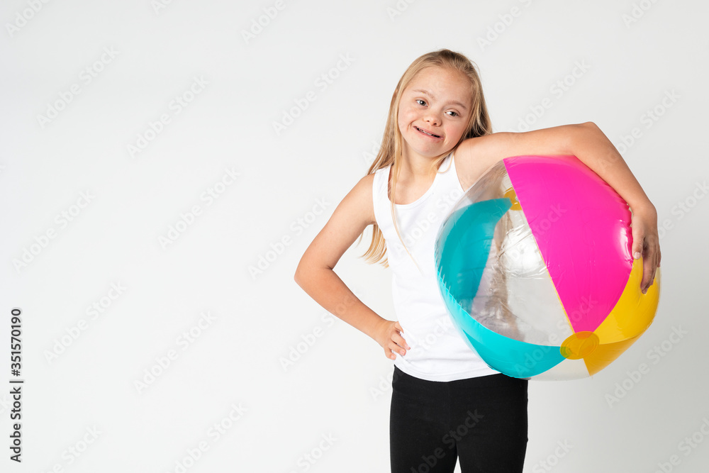 Cute little girl with Down Syndrome with a beach ball Cute little girl with Down Syndrome with a beach ball
