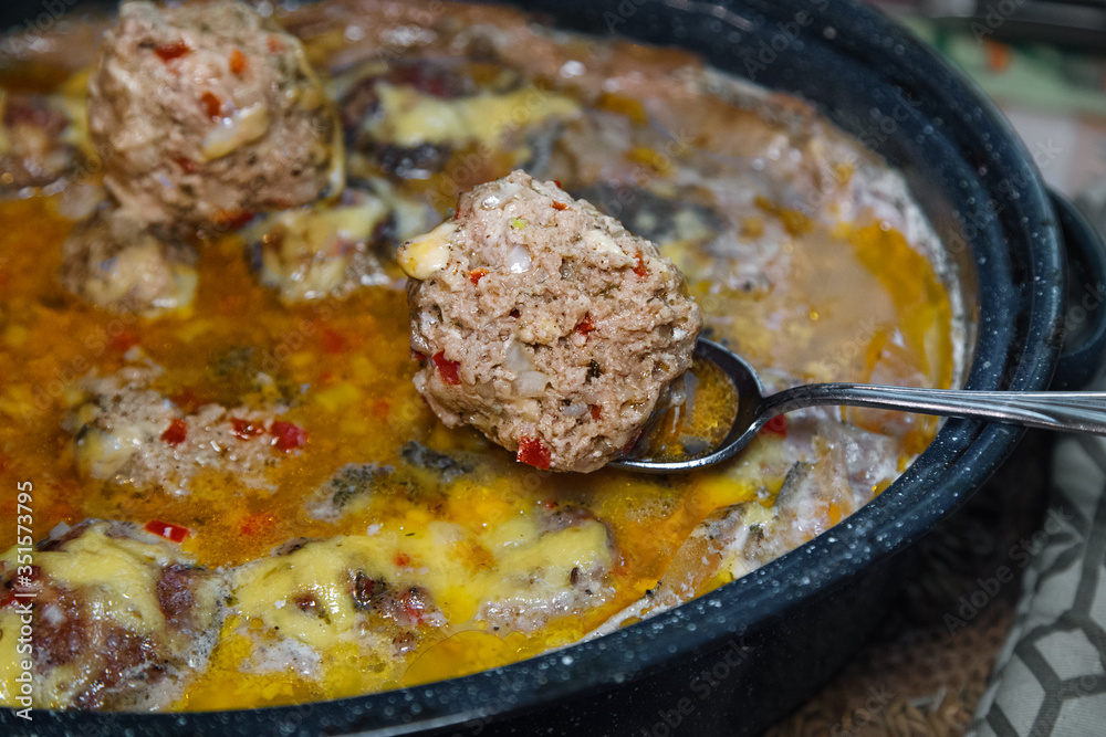 Homemade baked meatballs with vegetables and rice cooked in tomatoe and sour cream sauce.