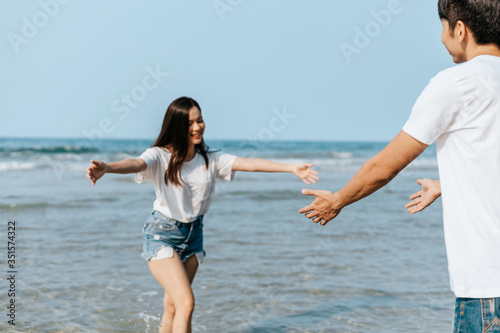 Happy couple in love on the beach. Woman running into men's embrace on the beach.
