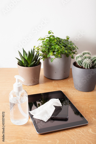 disinfecting tablet computer and smartphone screen, eliminating germs coronavirus bacteria photo