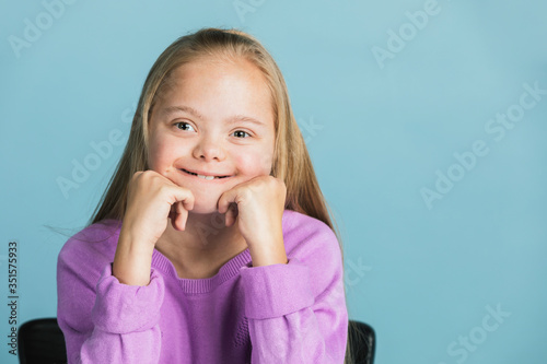 Cute girl with Down Syndrome in a purple sweater