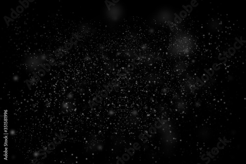 Dust particle on black abstract background. White dust element bokeh pattern flying in a dark
