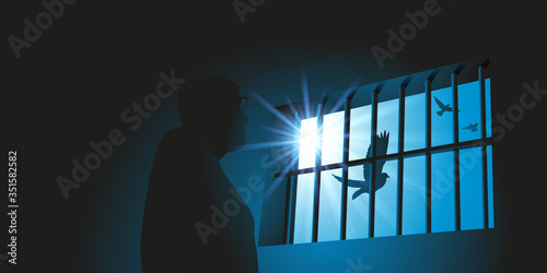 Concept de la prison et de la privation de liberté avec un prisonnier qui regarde un vol d’oiseau derrière des barreaux de la fenêtre de sa cellule.