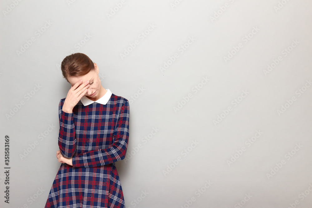Portrait of girl touching forehead with hand and tilting head down Portrait of girl touching forehead with hand and tilting head down