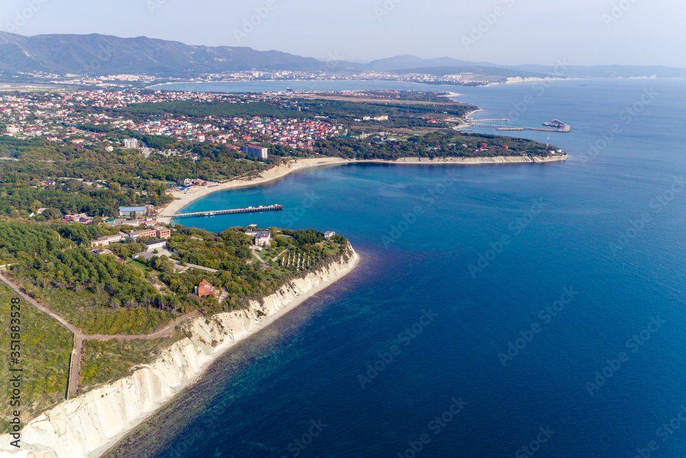 The Resort Of Gelendzhik. the area of Blue Bay. A small Bay with a beach and a sea pier. In the background the Gelendzhik Bay and the Markotkh mountain range