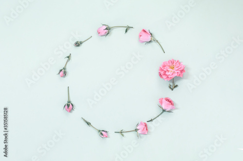 Frame made of pink roses on a soft background. Minimal concept, flat lay view with copy space for text