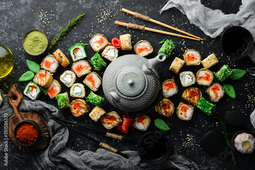 Set sushi rolls and tea ceremony with a teapot. Top view. Free space for your text.