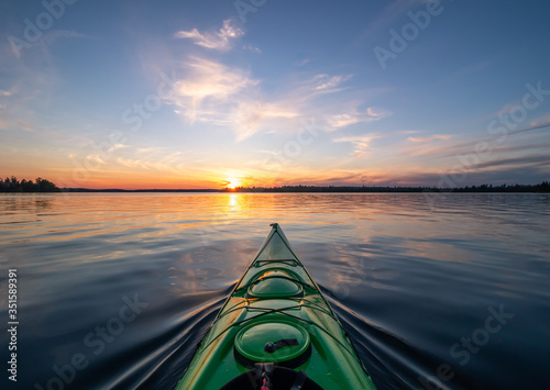 Kayaking at sunset on a calm lake in Northwest Ontario, Canada.