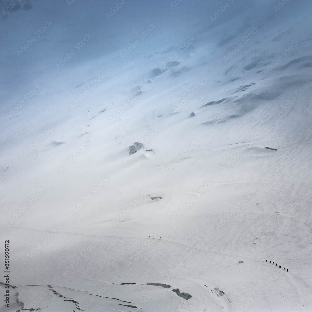 Scenic landscape of snowy mountains. Pamir Mountain System. Climbers making the ascent.