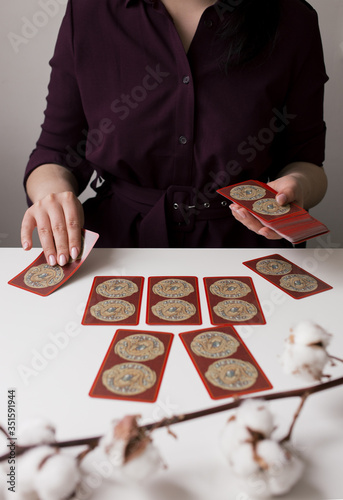 woman in dark shirt with tarot cards on the table