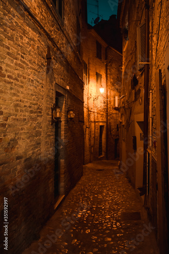 disturbing alley illuminated by typically medieval features photographed at night