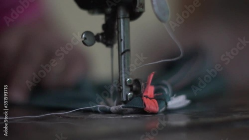 Needle of sewing machine with women's hand close-up of the needle slow motion