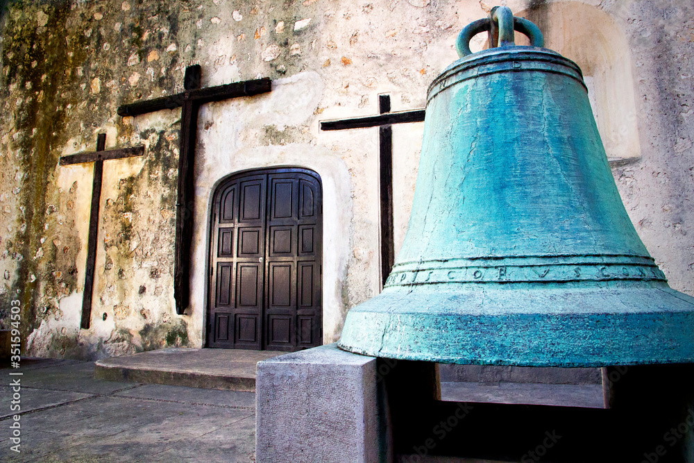 Fototapeta premium rosses and an old bell in a Mexican church in Merida, Mexico 