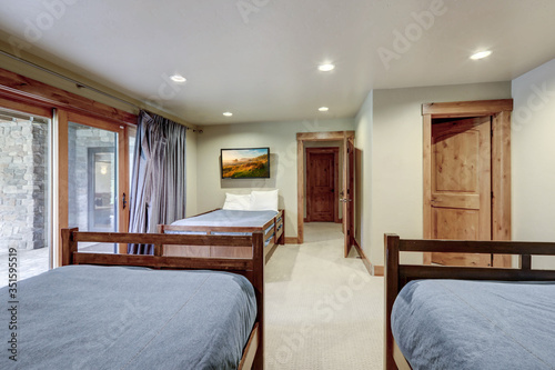 Guest bedroom with three double beds and TV on the wall.