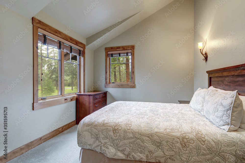 Beautiful calm soft grey bedroom interior with vaulted ceiling, lots of indows and light color bedding. Beautiful calm soft grey bedroom interior with vaulted ceiling, lots of indows and light color bedding.
