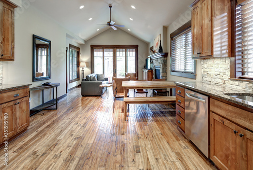 Luxury middle tone wood rich kitchen interior with grey natural stone  tiles backsplash and quarts countertop. © Iriana Shiyan