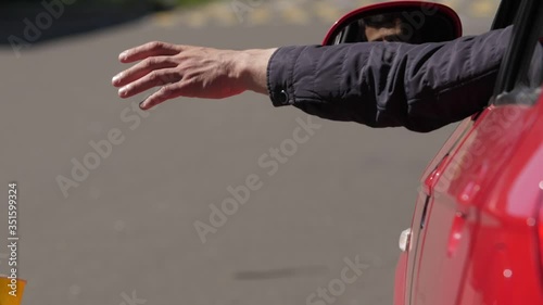 A man throws out a plastic cup from the car