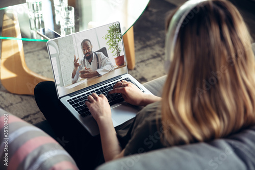 Bild auf Leinwand Young woman getting online medical help and advice during videocall with doctor checking symtoms aand explaining the drug's reciepes