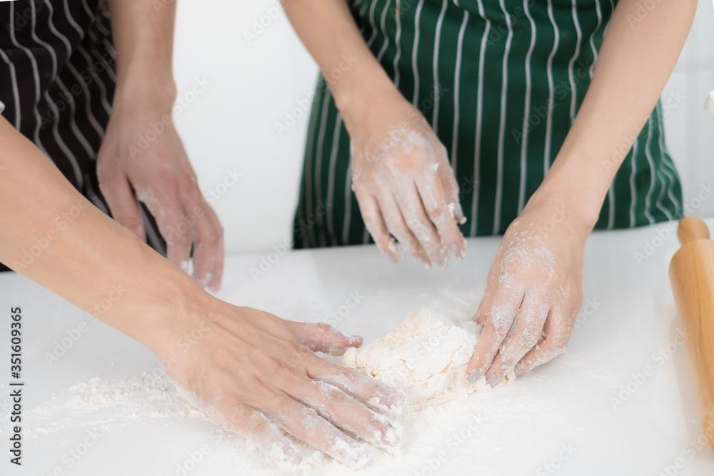 Romantic young Asian couple prepare cooking thresh flour together in white kitchen.Cloes up hand view.