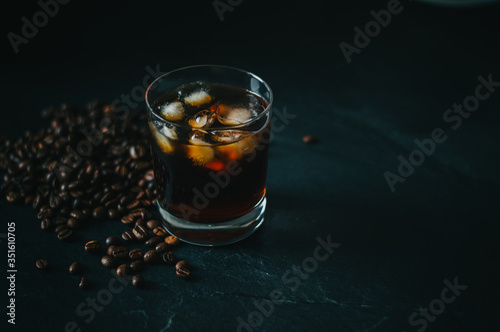 Cold Brew Coffee in Whiskey glass on a countertop with coffee beans