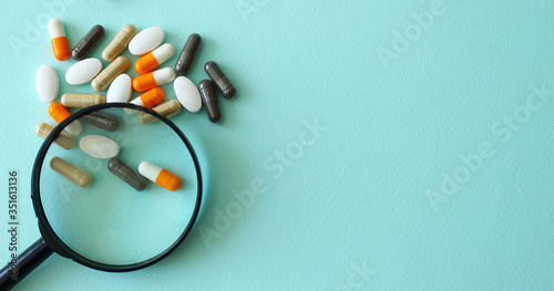 The pills under scrutiny.medicine, drug, vitamin, pharmacy,magnifier,concept
