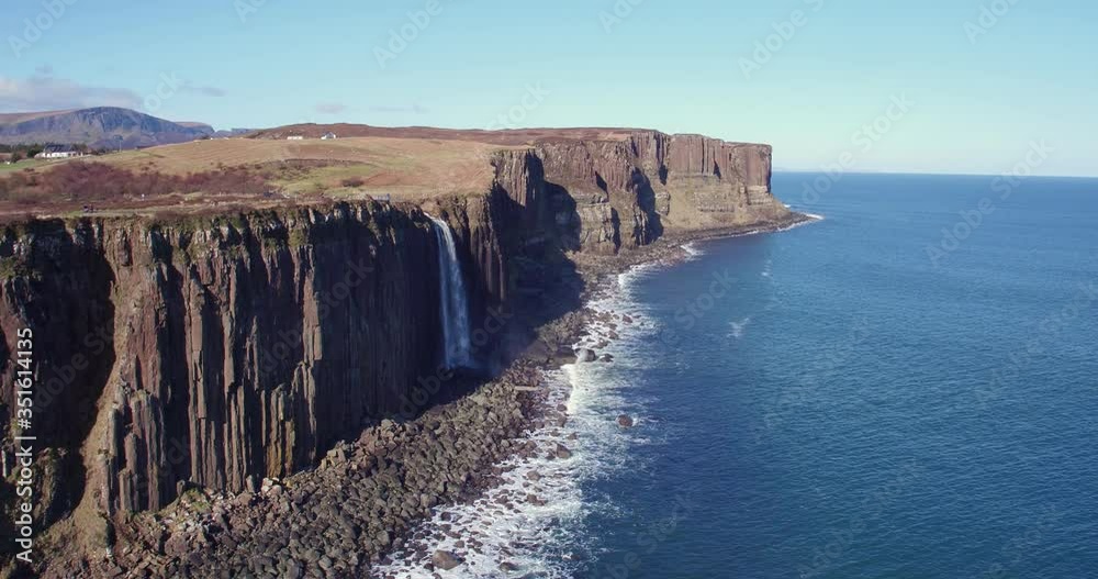 Huge waterfall falling off of cliff and into the sea. Beautiful Kilt Rock, Skeye, from above