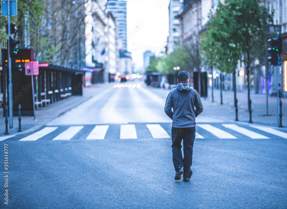 Caucasian man walking on an empty street