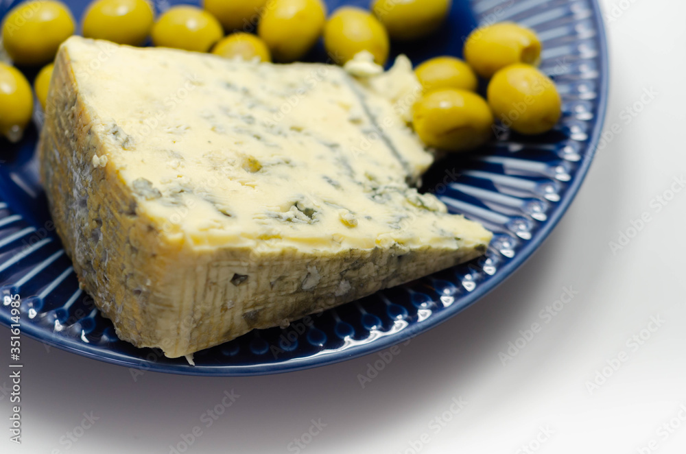 Full fat soft blue veined cheese and pickled olives stuffed garlic on the blue plate